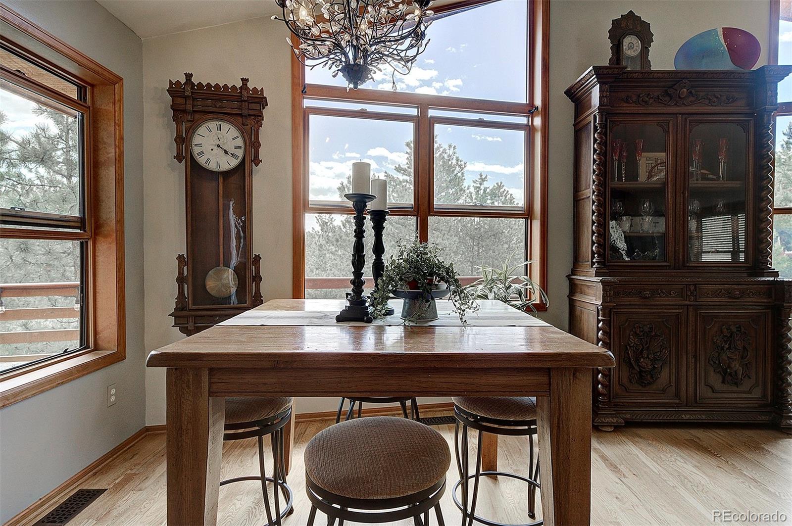 29659 Spruce Road Evergreen, CO 80439 - Photo 15 of 38 a view of a dining room with furniture window and wooden floor