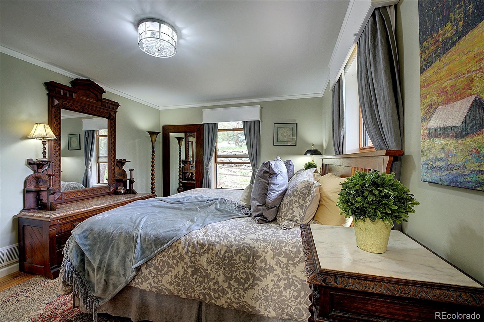 29659 Spruce Road Evergreen, CO 80439 - Photo 24 of 38 a bedroom with a bed potted plant with the dresser