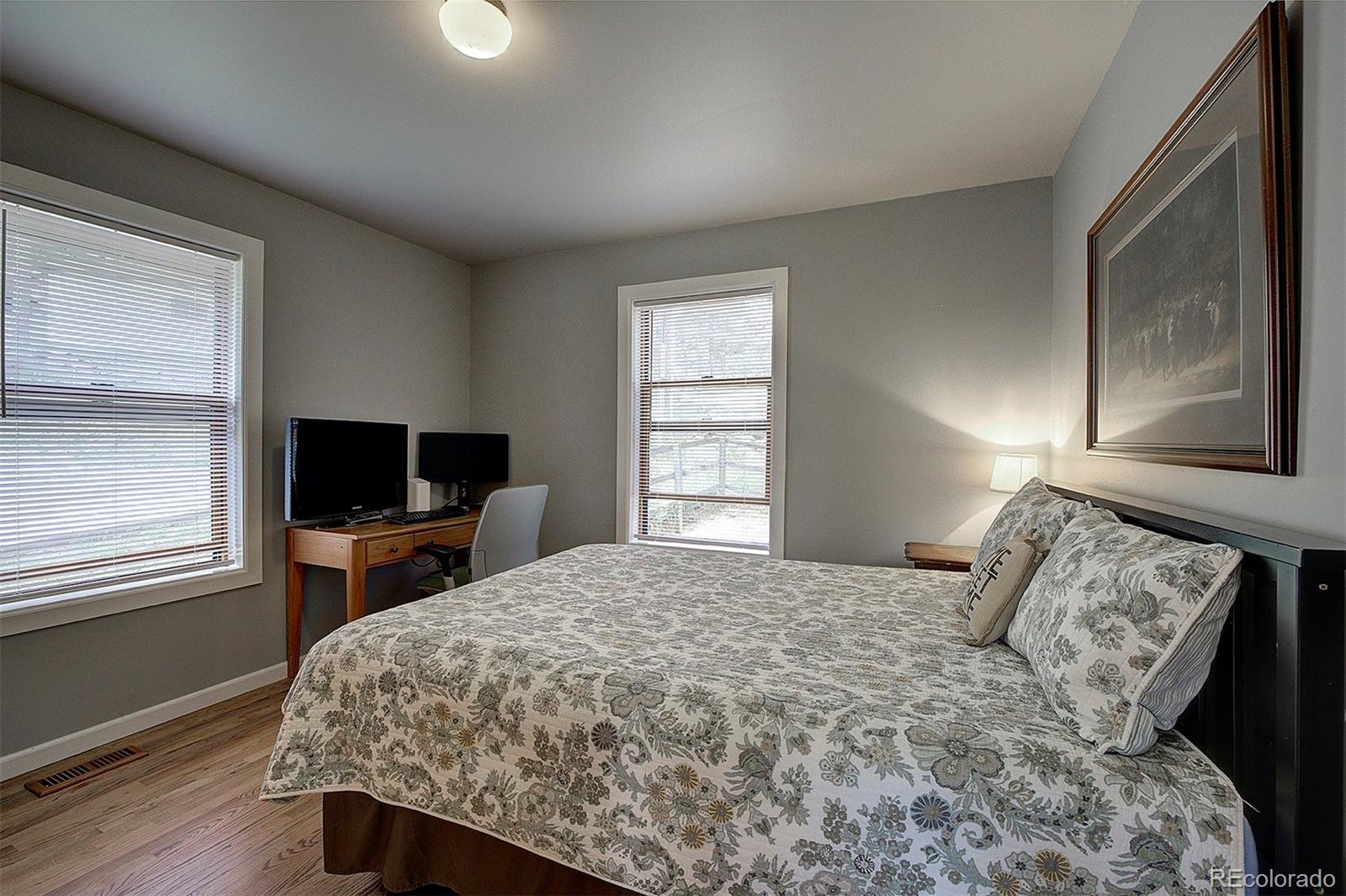 29659 Spruce Road Evergreen, CO 80439 - Photo 26 of 38 a bedroom with a bed and a flat tv screen on a dresser