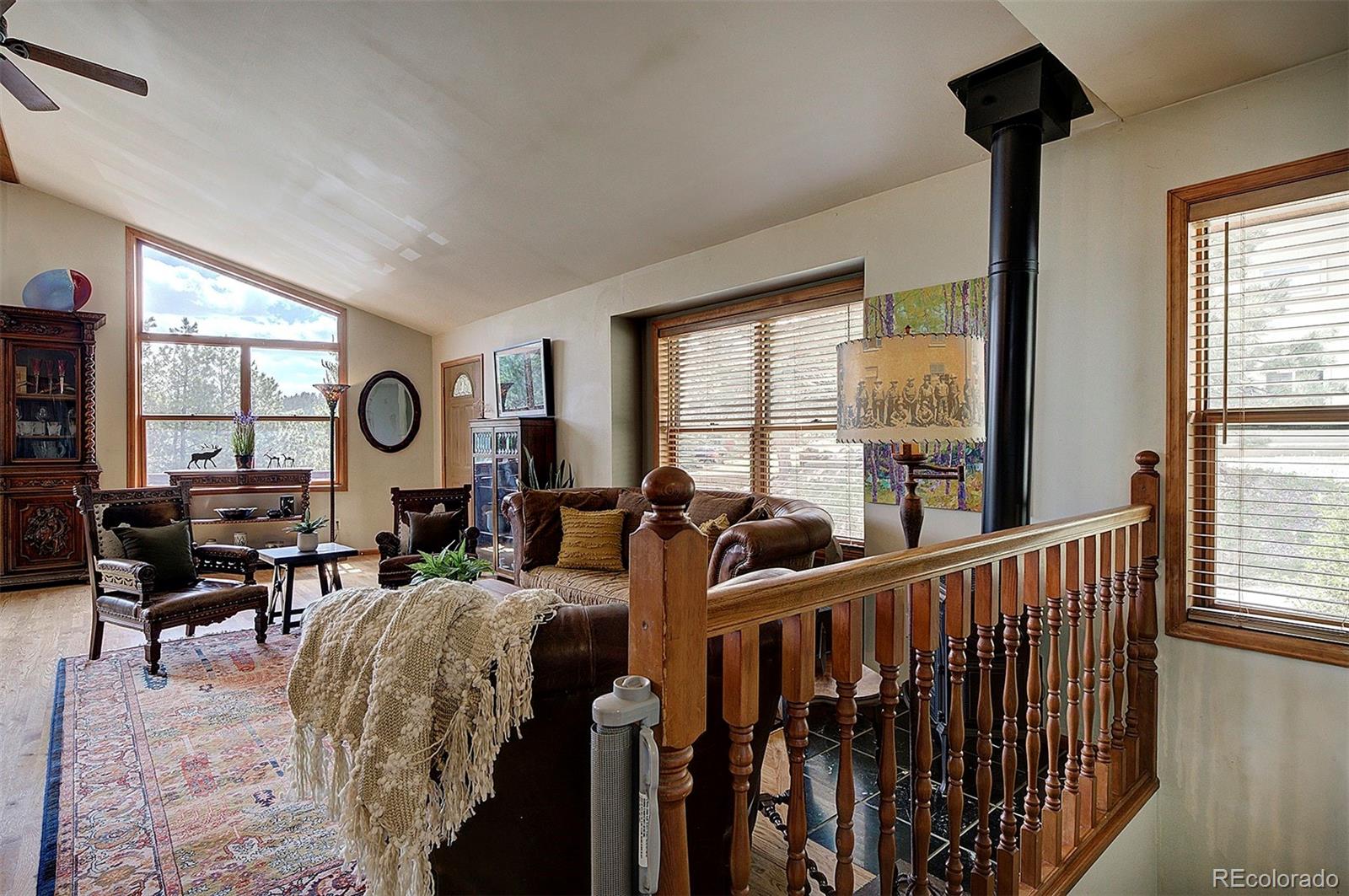 29659 Spruce Road Evergreen, CO 80439 - Photo 27 of 38 a living room with furniture fireplace and a large window