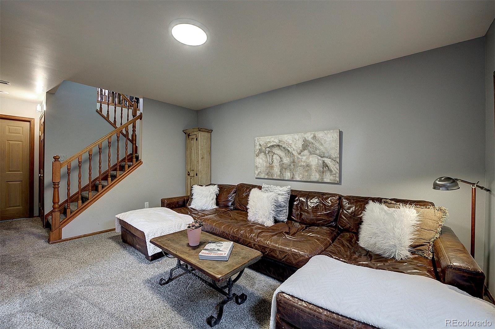 29659 Spruce Road Evergreen, CO 80439 - Photo 28 of 38 a living room with couches and a dining table with rug