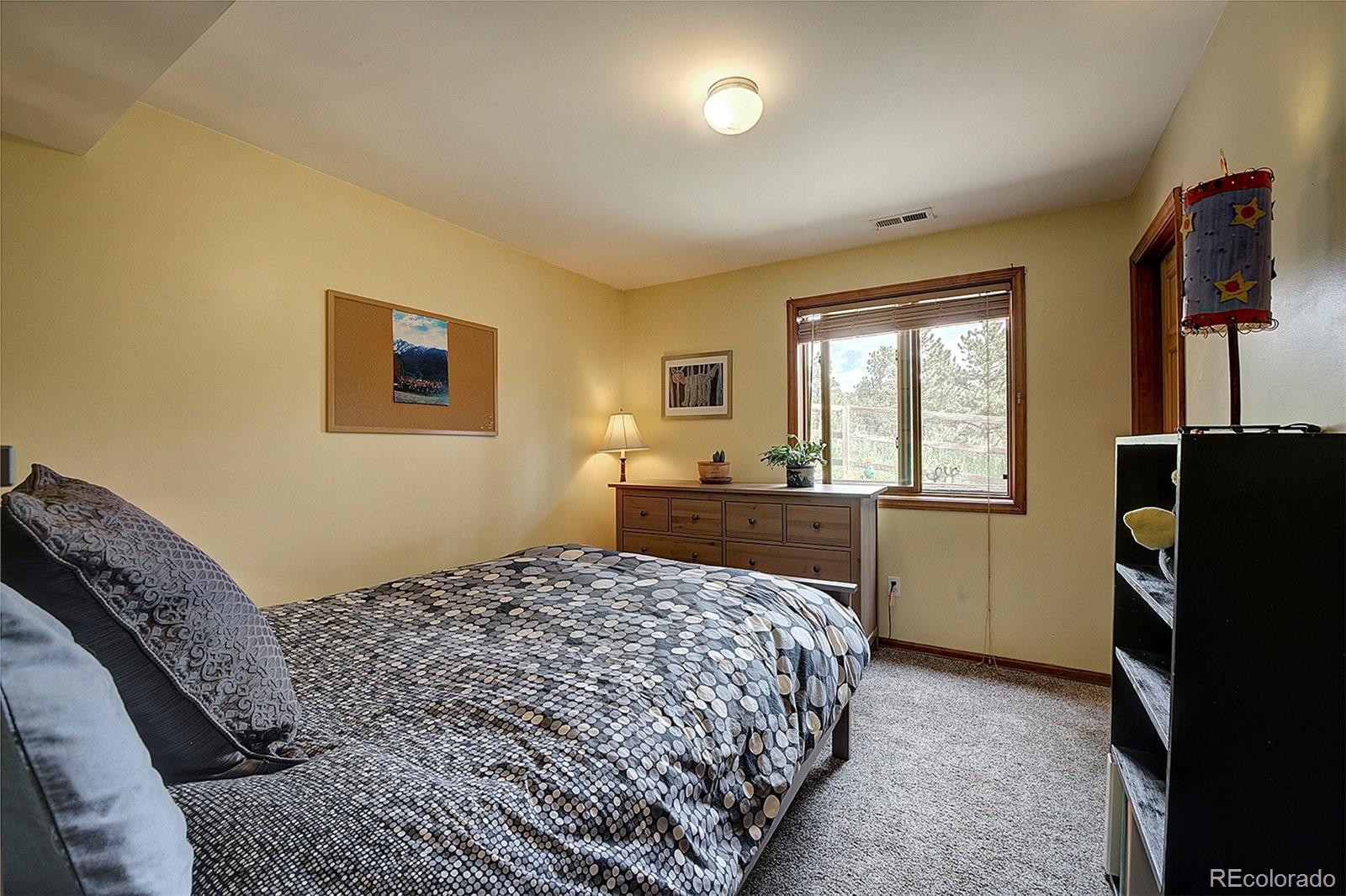 29659 Spruce Road Evergreen, CO 80439 - Photo 30 of 38 a bedroom with a bed and a refrigerator