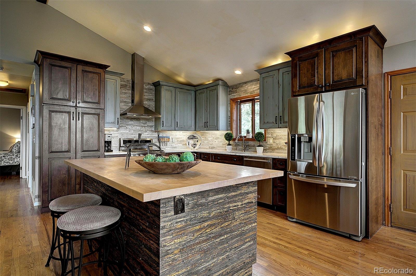 29659 Spruce Road Evergreen, CO 80439 - Photo 9 of 38 a kitchen with kitchen island a counter and a refrigerator