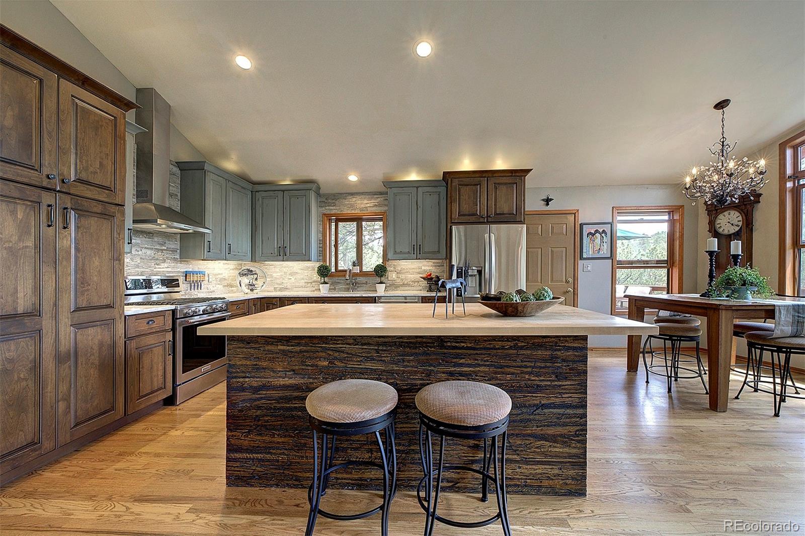29659 Spruce Road Evergreen, CO 80439 - Photo 10 of 38 a kitchen with kitchen island granite countertop a sink cabinets and stainless steel appliances