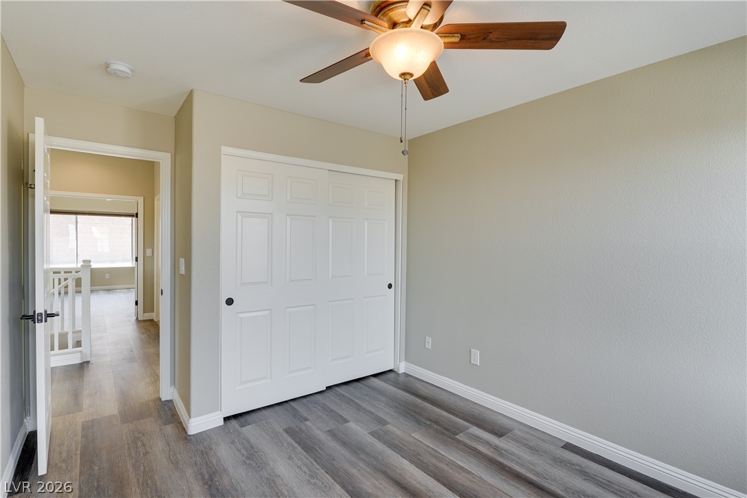 703 Principle Point Avenue Henderson, NV 89012 - Photo 27 of 29 Well-lit room features wood-look flooring and a ceiling fan, with a convenient sliding door closet.
