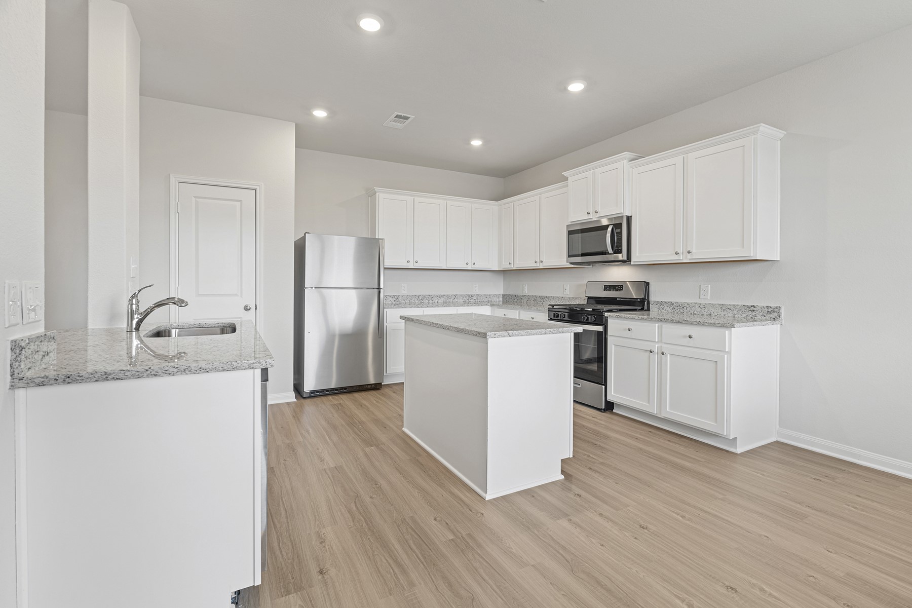 8830 Ice Quartz Drive Iowa Colony, TX 77583 - Photo 5 of 18 a kitchen with stainless steel appliances a refrigerator sink and white cabinets