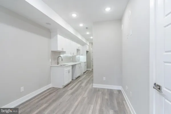 a view of a kitchen with white cabinets and wooden floor