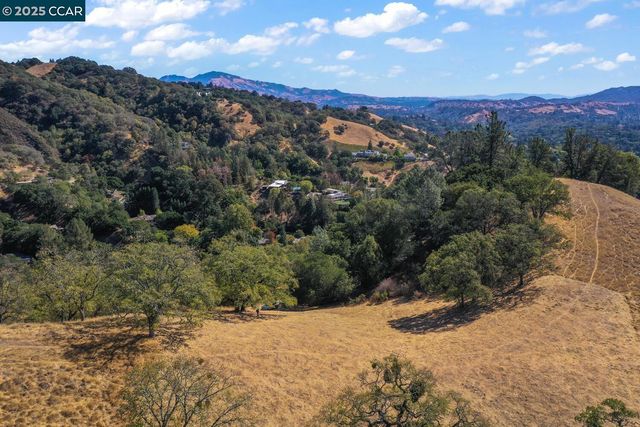 a view of a dry yard with mountains in the background