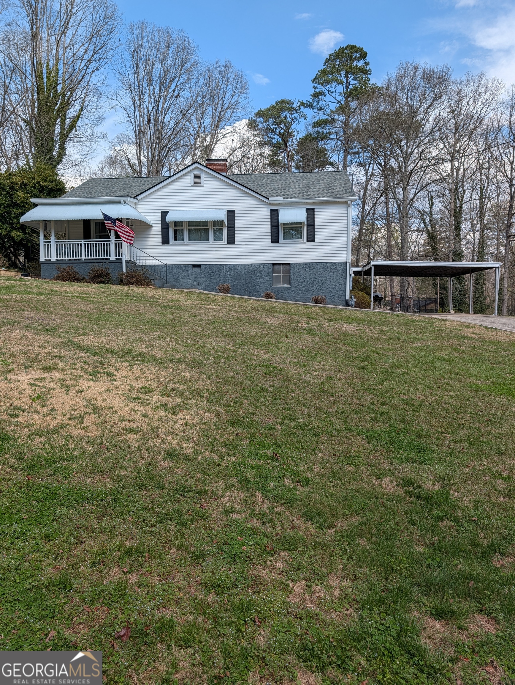 a front view of house with yard and trees in the background