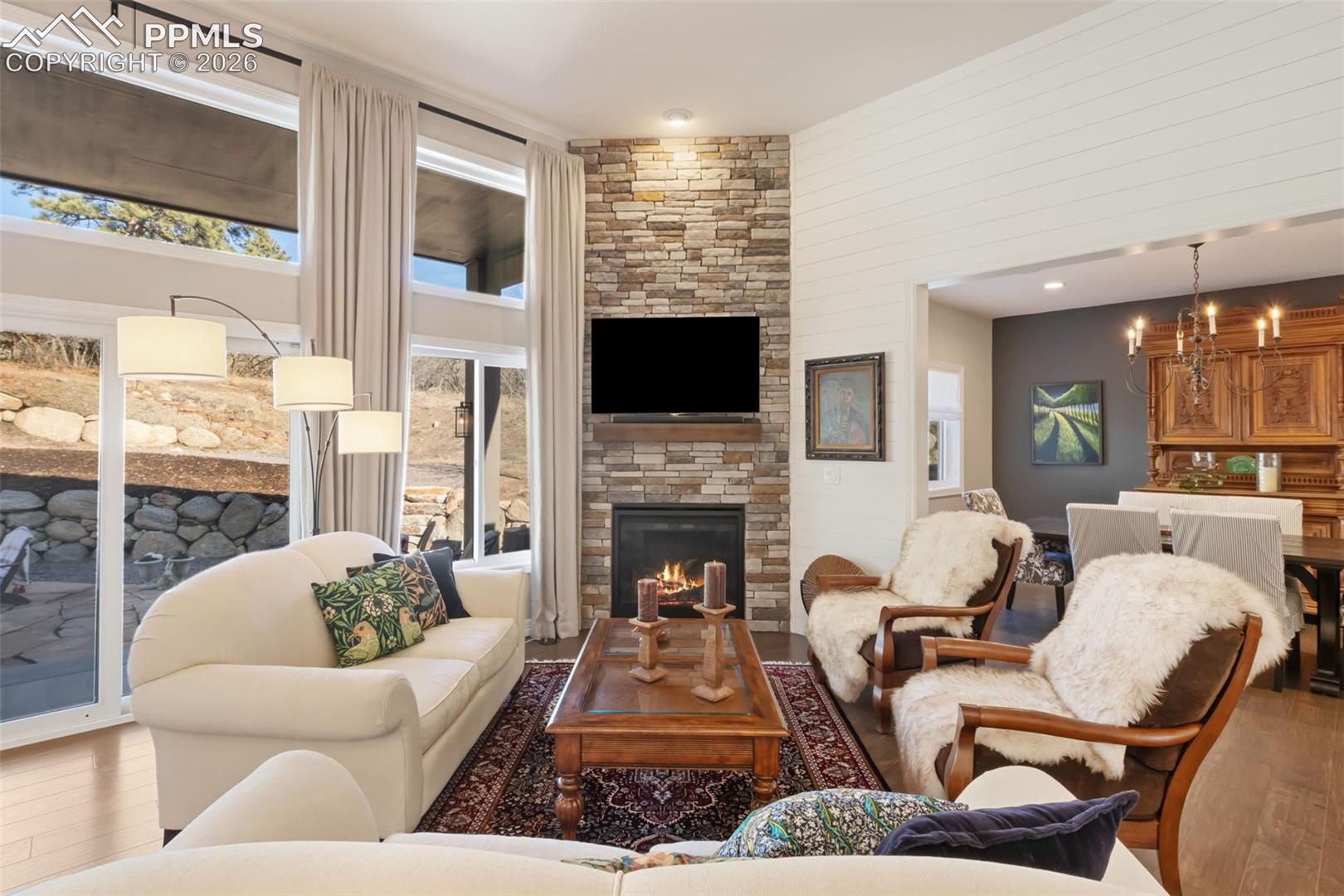 5318 Rocking Tree Grove Colorado Springs, CO 80906 - Photo 4 of 49 The primary living area is anchored by a floor-to-ceiling stone fireplace, creating a warm, centralized gathering space that flows effortlessly into the formal dining room