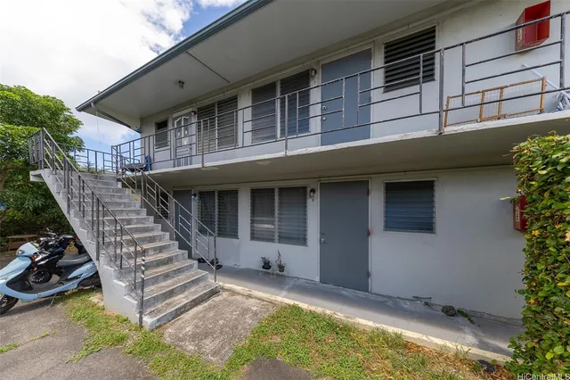 a view of a house with wooden stairs and a small yard