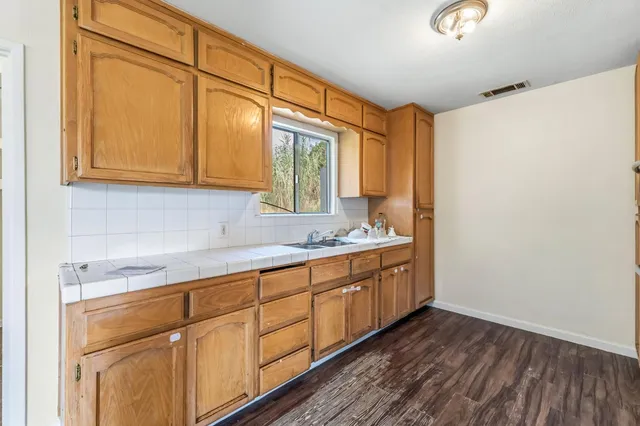 a bathroom with a granite countertop sink and a mirror