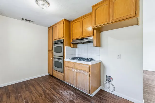 a kitchen with wooden cabinets and a stove top oven