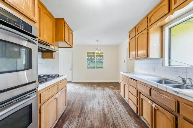 a kitchen with granite countertop a stove and a sink