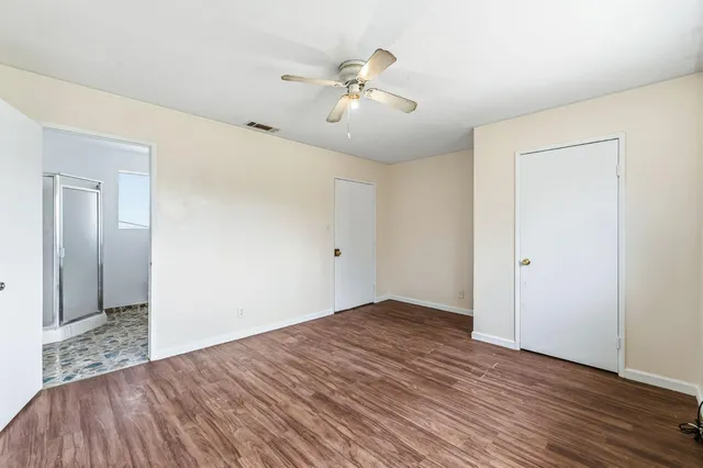 a view of an empty room with wooden floor
