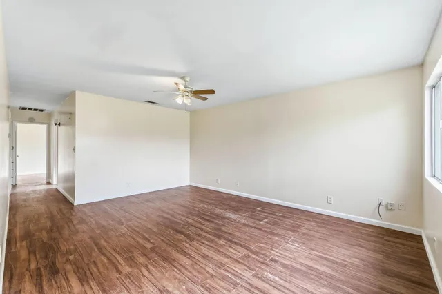 a view of an empty room with wooden floor