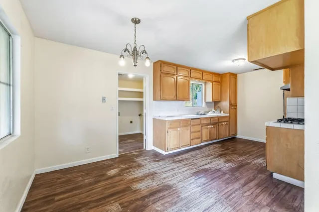 a large kitchen with stainless steel appliances a large counter top a sink a stove and a refrigerator