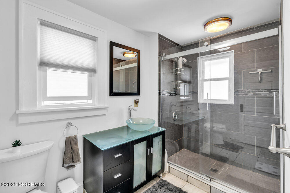 208 East Bergen Place Red Bank, NJ 07701 - Photo 15 of 25 a bathroom with a granite countertop sink a toilet and shower