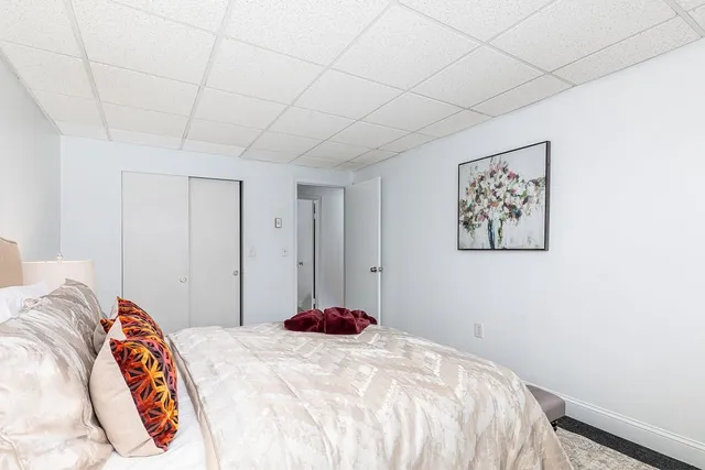 a bedroom with a bed and a painting on the wall