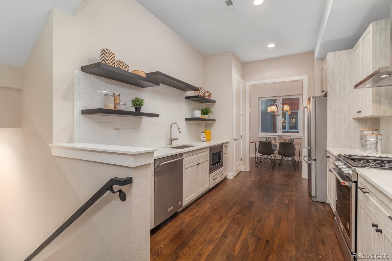 927 Inca Street, Unit 3 Denver, CO 80204 - Photo 7 of 24 a kitchen with stainless steel appliances a sink and wooden floor