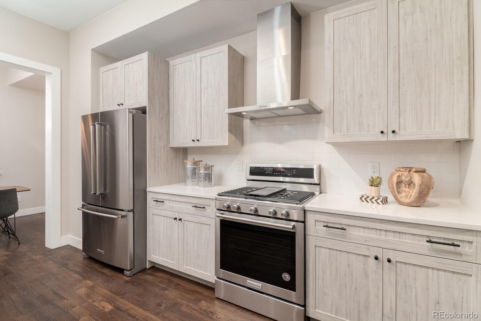 927 Inca Street, Unit 3 Denver, CO 80204 - Photo 8 of 24 a kitchen with stainless steel appliances granite countertop a refrigerator stove and white cabinets