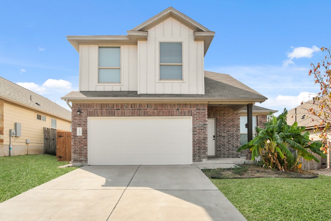 a front view of a house with a garden and plants