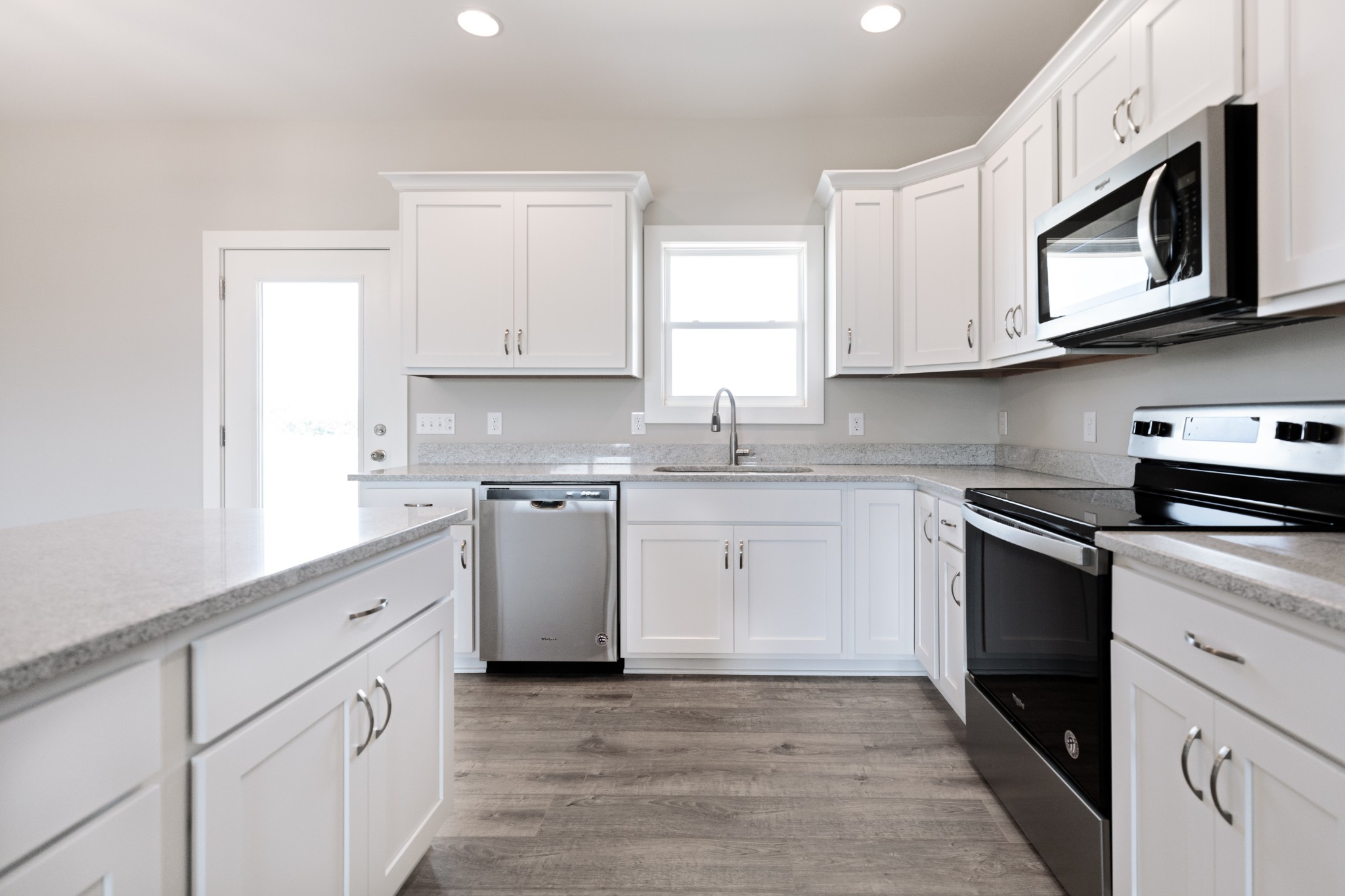 246 Woodruff Road Adams, TN 37010 - Photo 4 of 18 a kitchen with stainless steel appliances granite countertop white cabinets sink and window