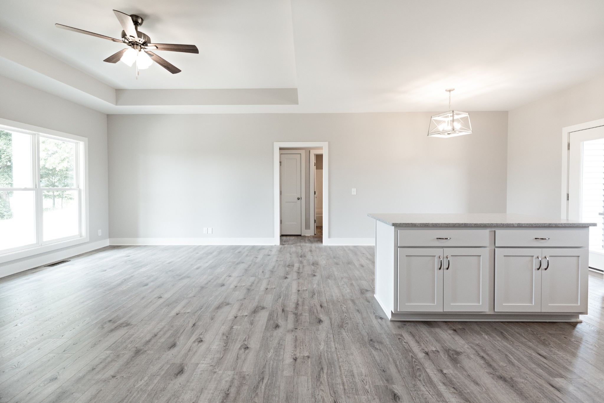 246 Woodruff Road Adams, TN 37010 - Photo 6 of 18 an empty room with wooden floor ceiling fan and windows
