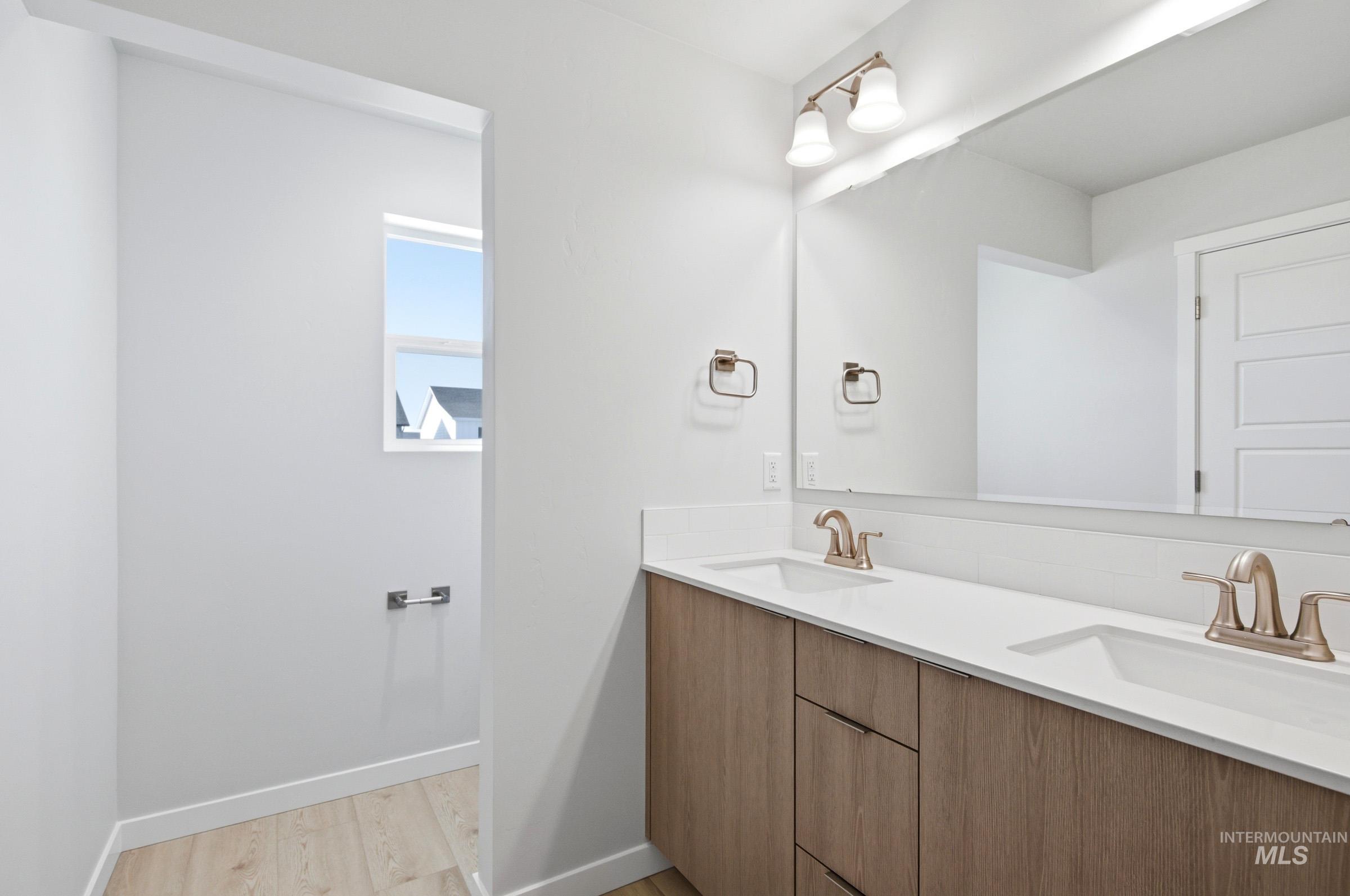 10800 Rutland Street Caldwell, ID 83605 - Photo 19 of 21 Double vanity featuring wood-finish cabinetry, white countertops, and brushed nickel fixtures