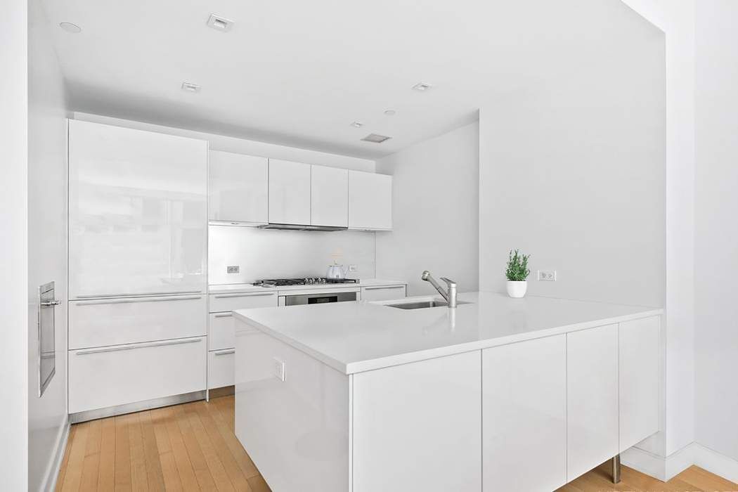 5 East 44th Street, Unit 12 Manhattan, NY 10017 - Photo 4 of 11 a kitchen with a sink cabinets and white appliances