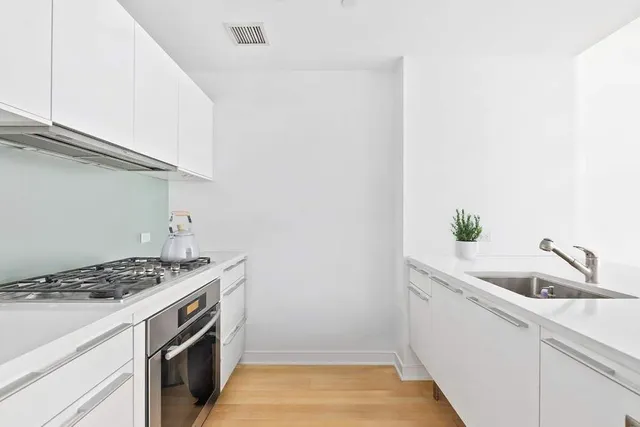 a kitchen with a sink cabinets and white appliances