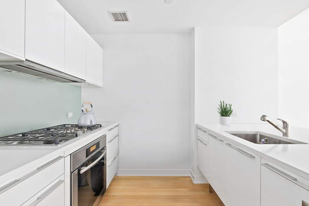 5 East 44th Street, Unit 12 Manhattan, NY 10017 - Photo 5 of 11 a kitchen that has a sink and a stove