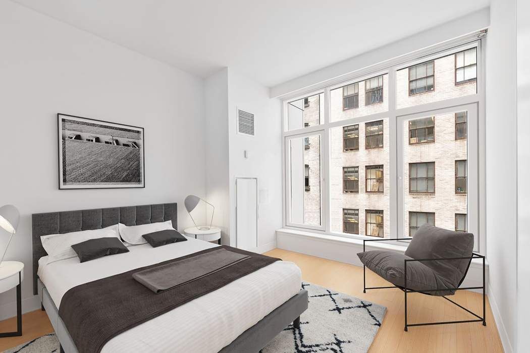 5 East 44th Street, Unit 12 Manhattan, NY 10017 - Photo 6 of 11 a bedroom with a bed and wooden floor