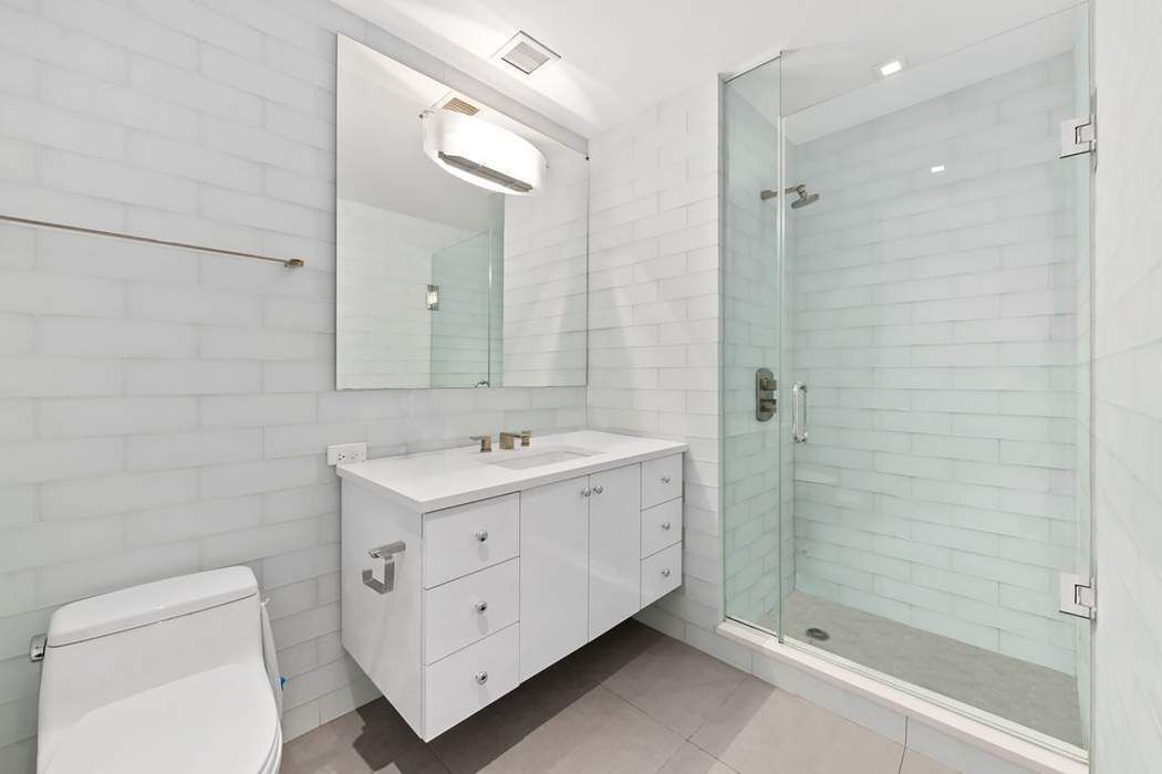 5 East 44th Street, Unit 12 Manhattan, NY 10017 - Photo 9 of 11 a view of bathroom with a sink a toilet and shower