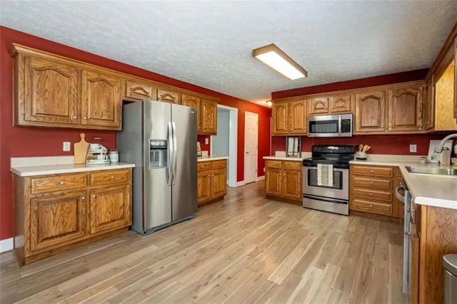a kitchen with stainless steel appliances a refrigerator and wooden cabinets