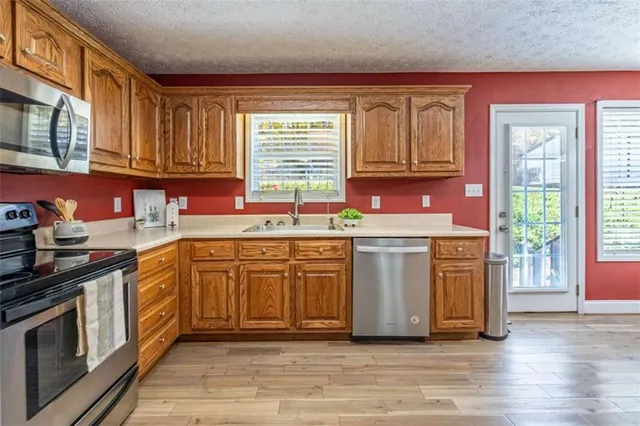 a kitchen with stainless steel appliances granite countertop a stove a sink and a microwave