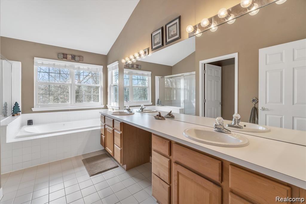 201 Timber Ridge Drive Highland, MI 48357 - Photo 21 of 39 Four piece en-suite bath with jetted tub, dual sinks, and separate toilet and shower