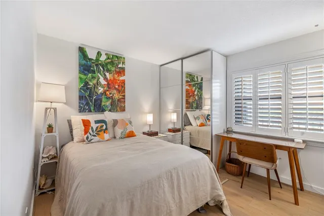 a bedroom with a bed and a wooden floor