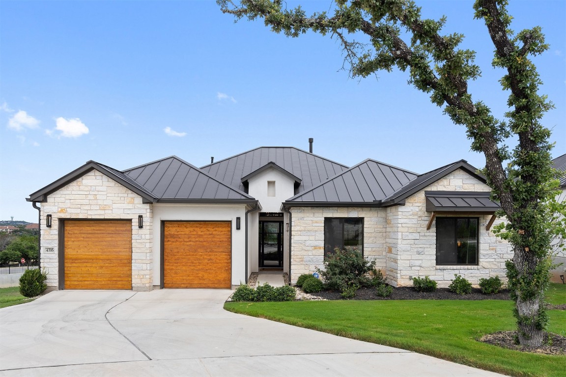 a front view of a house with a garden and yard