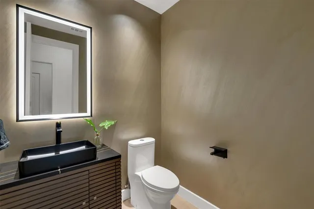 a bathroom with a toilet a sink and mirror
