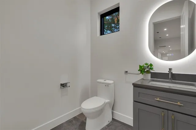 a bathroom with a toilet a sink and mirror