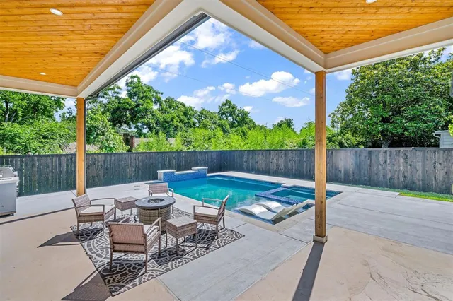 a backyard of a house with fountain table and chairs