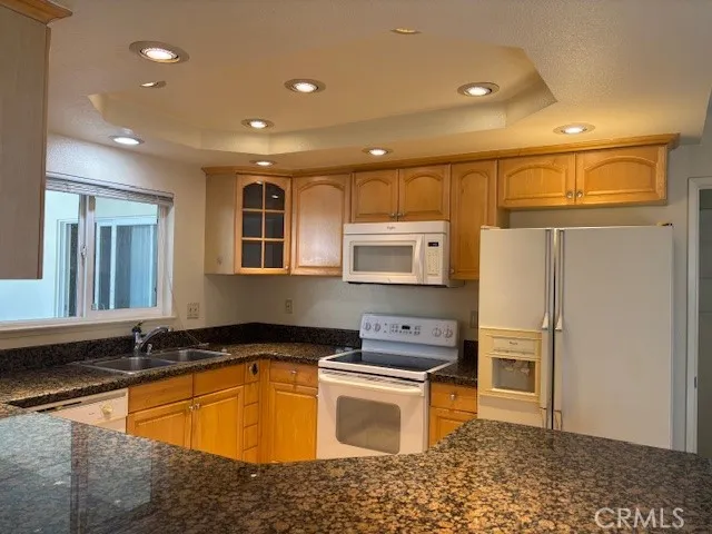 a kitchen with granite countertop a refrigerator and a sink