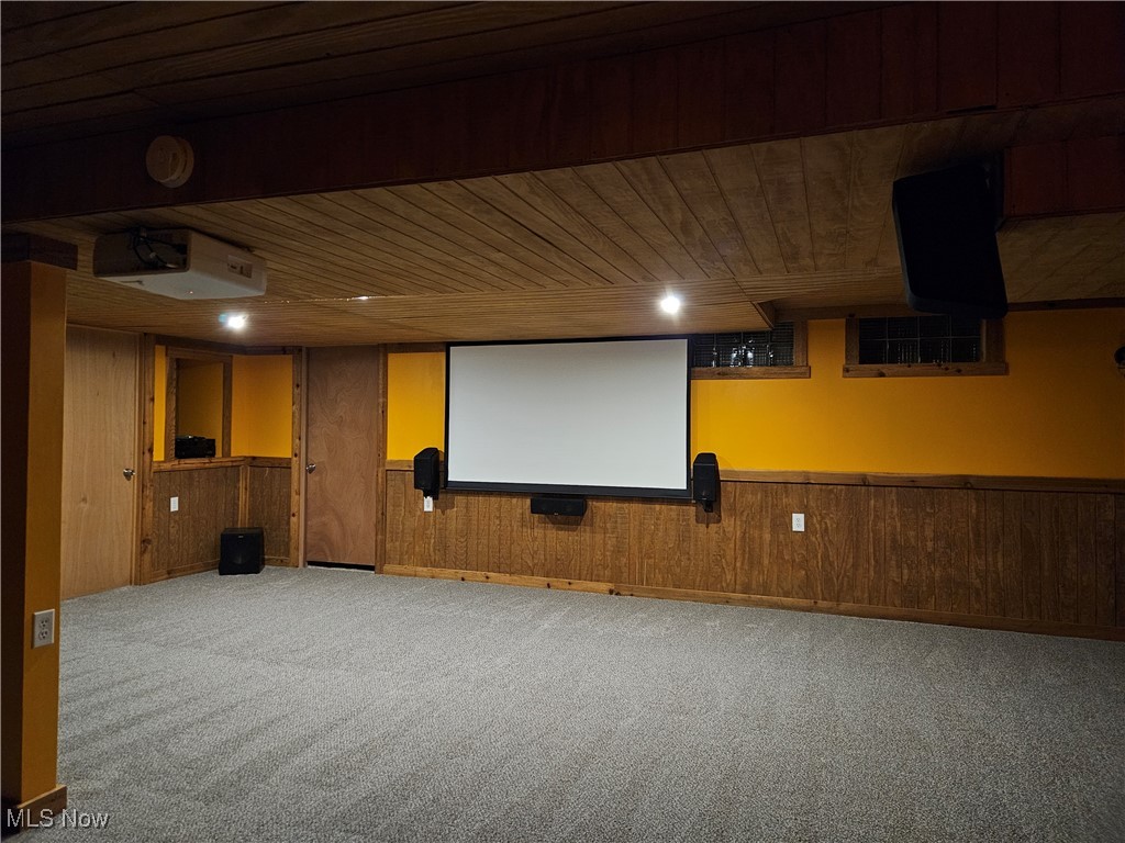 6155 Beach Road Wadsworth, OH 44281 - Photo 33 of 49 Basement home theater area with projector, retractable screen, surround sound, featuring wooden ceiling and walls with carpeted floors