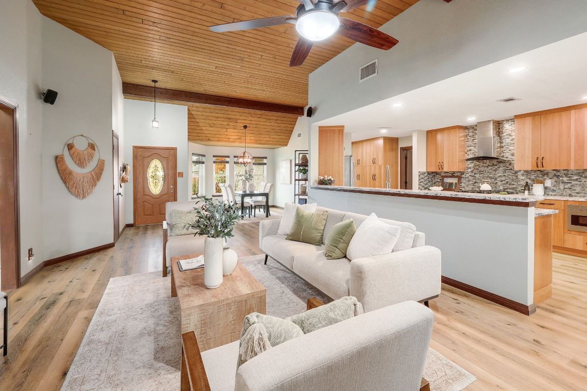 a living room with furniture a chandelier and a dining table