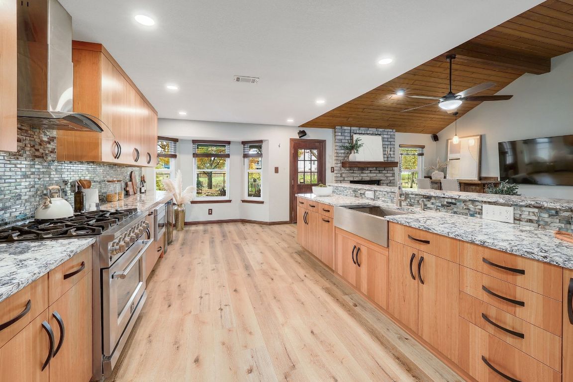 2307 Silverleaf Cove Round Rock, TX 78664 - Photo 3 of 31 a large kitchen with stainless steel appliances granite countertop a large stove a sink dishwasher and a microwave oven with large wooden cabinets