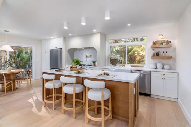 a kitchen with a sink and chairs