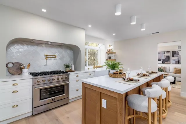 a kitchen with a stove and chairs