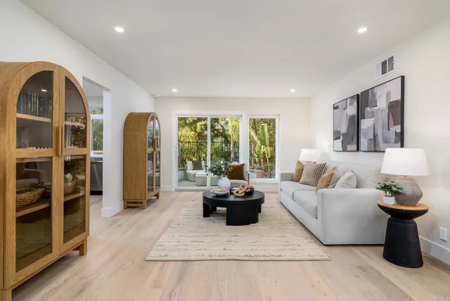 a living room with furniture a rug and white walls