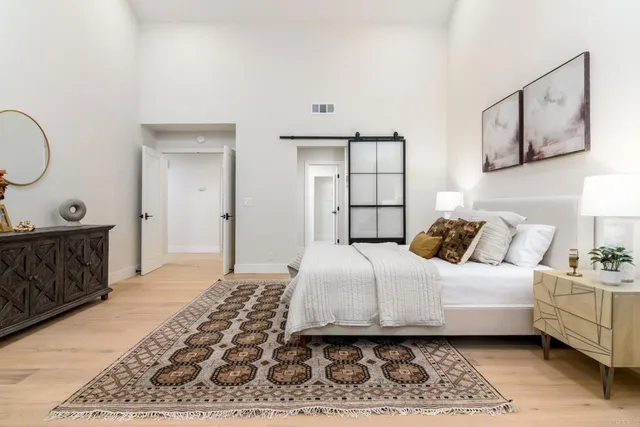 a bedroom with a bed a mirror and lamp